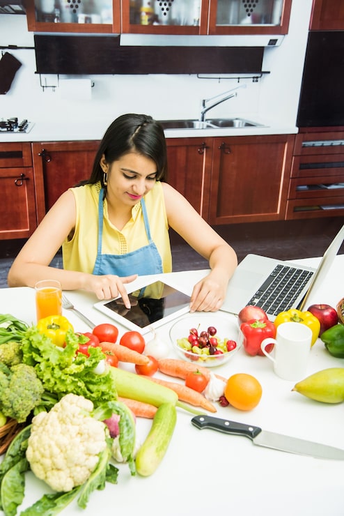 Woman multitasking in kitchen prepping | Holistic Menus