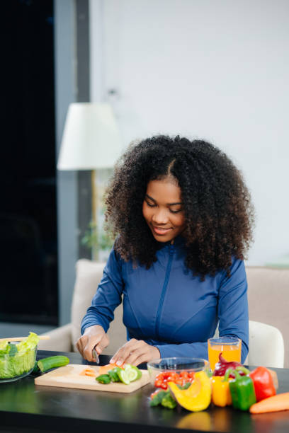 Smiling woman chopping fresh vegetables | Holistic Menus